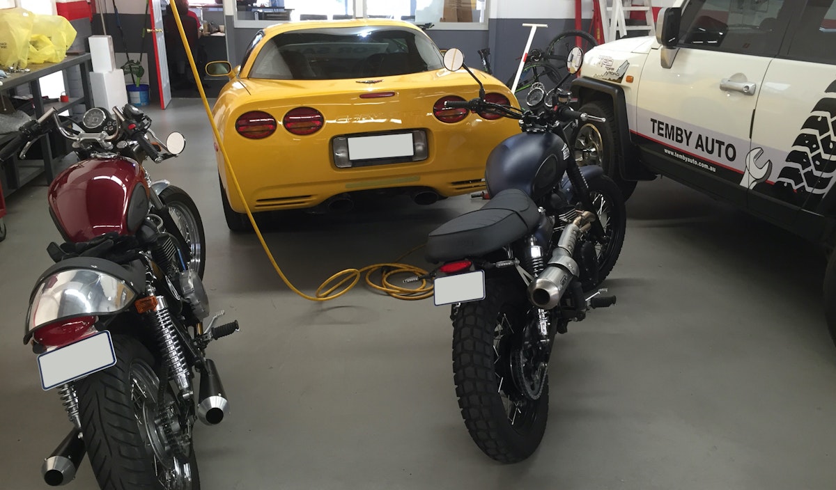 We also service, repair and restore motorbikes in our workshop. Check out these two bikes, a Triumph Bonneville 2008 and a Triumph Scrambler 2014. Both individualy built up here at Tembyland. In the background you can see the rear of another collectable sports car, a 
Yellow Corvette C5 1998.